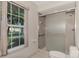 Well-lit bathroom with glass-enclosed shower and window at 1443 Quail Lake Dr, Venice, FL 34293