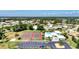 Aerial view featuring tennis courts, community pool, clubhouse, parking and surrounding homes in a well-maintained area at 1443 Quail Lake Dr, Venice, FL 34293