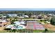 Aerial view featuring tennis courts, community pool, clubhouse, parking and surrounding homes in a well-maintained area at 1443 Quail Lake Dr, Venice, FL 34293