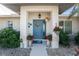 Welcoming entrance with a blue door and red flower pots at 1521 Saint Clair Rd, Englewood, FL 34223