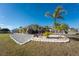 Well-manicured lawn, palm trees, and a gravel driveway at 1521 Saint Clair Rd, Englewood, FL 34223