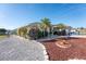 Landscaped front yard with palm trees and gravel driveway at 1521 Saint Clair Rd, Englewood, FL 34223