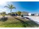 Landscaped yard with palm trees and a paved driveway at 1521 Saint Clair Rd, Englewood, FL 34223