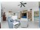 Bright living room features comfy seating, built-in shelving, and a large TV at 1521 Saint Clair Rd, Englewood, FL 34223