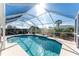 Relaxing screened-in pool area with tiled deck and grilling station at 1521 Saint Clair Rd, Englewood, FL 34223