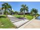 Landscaped backyard with a walkway leading to the canal at 15794 Viscount Cir, Port Charlotte, FL 33981