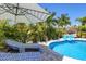 Inviting pool area with lounge chairs and umbrella at 15794 Viscount Cir, Port Charlotte, FL 33981