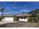 Brick house with a white garage door and a well-maintained lawn at 1755 Georgia Ne Ave, St Petersburg, FL 33703