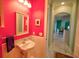 Small powder room with pedestal sink and vibrant pink walls at 2 Windward Rd, Placida, FL 33946