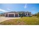 House exterior showcasing a three-car garage, manicured lawn and tile roof at 2 Windward Rd, Placida, FL 33946