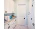 Functional laundry room with white cabinets and granite countertops at 2 Windward Rd, Placida, FL 33946