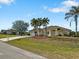 Single-story house with a two-car garage, palm trees, and green lawn at 2295 Chilcote Ter, Port Charlotte, FL 33981