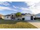 Single-story home with a two-car garage and landscaped lawn at 23111 Mineral Ave, Port Charlotte, FL 33954