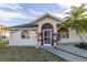 Front view of a house with a screened entryway and palm trees at 23111 Mineral Ave, Port Charlotte, FL 33954