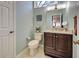 Cozy bathroom with a granite vanity, toilet, and blue wall at 232 Southampton Ln # 259, Venice, FL 34293