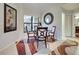 Cozy dining area featuring a round glass table with seating for four, a decorative mirror, and a modern area rug at 232 Southampton Ln # 259, Venice, FL 34293