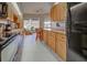 Functional kitchen featuring wood cabinetry, black appliances, and a breakfast bar with a view to the outside at 232 Southampton Ln # 259, Venice, FL 34293