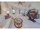 Bright living room with white furniture, a glass-top coffee table, and views into the dining room at 232 Southampton Ln # 259, Venice, FL 34293