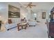 Bright living room with a white sofa and loveseat, a glass-top coffee table, and a ceiling fan at 232 Southampton Ln # 259, Venice, FL 34293