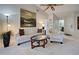 Bright living room with white furniture, ceiling fan, and views into the dining room and bathroom at 232 Southampton Ln # 259, Venice, FL 34293