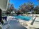 Outdoor pool with clear blue water, surrounded by chairs and mature trees, under a bright blue sky at 232 Southampton Ln # 259, Venice, FL 34293