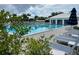 Community swimming pool, surrounding deck, and sun loungers on a sunny day at 232 Southampton Ln # 259, Venice, FL 34293