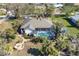 Aerial view of a home with lush landscaping, an outdoor fire pit, and screened-in pool at 235 Capstan Dr, Placida, FL 33946