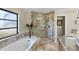 Spa-like bathroom featuring a soaking tub, glass-enclosed shower, granite counters, and elegant finishes at 235 Capstan Dr, Placida, FL 33946