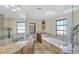 Relaxing bathroom with a large tub, glass shower, double sinks, and natural light from a skylight at 235 Capstan Dr, Placida, FL 33946