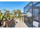 Wooden deck featuring tropical plants that lead to a screened-in pool and backyard area at 235 Capstan Dr, Placida, FL 33946