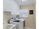 Laundry room features a washer, dryer, sink and white cabinets at 235 Capstan Dr, Placida, FL 33946