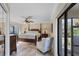 Comfortable main bedroom featuring a four-poster bed, ceiling fan, and sliding glass door to the outdoors at 235 Capstan Dr, Placida, FL 33946