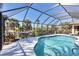 Enclosed pool area with patio table and seating, complemented by lush tropical landscaping and bright sunlight at 235 Capstan Dr, Placida, FL 33946