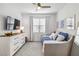 Well-lit bedroom with a daybed, dresser, and a large window at 24269 Spartina Dr, Venice, FL 34293