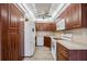 Kitchen with dark wood cabinets and white appliances at 25188 Marion Ave # C206, Punta Gorda, FL 33950