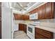 Kitchen with dark wood cabinets and white appliances at 25188 Marion Ave # C206, Punta Gorda, FL 33950