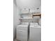 Bright laundry area with washer, dryer and overhead storage at 25188 Marion Ave # C206, Punta Gorda, FL 33950