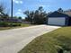 Long concrete driveway leading to a detached garage at 2933 Vizza Ln, North Port, FL 34286