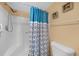 Clean bathroom with shower, toilet and blue patterned curtain at 3310 Loveland Blvd # 802, Punta Gorda, FL 33980