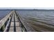 Long wooden pier over the water, featuring railing and calm water at 4410 Warren Ave # 403, Port Charlotte, FL 33953