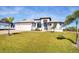 Single-story home with a large yard, two-car garage, and attractive landscaping at 48 Master Dr, Placida, FL 33946