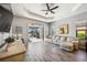 Spacious living room with beige sectional, wood-look tile, and view of pool at 484 Casalino Dr, Nokomis, FL 34275