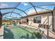 Inviting pool area with screened enclosure, patio furniture, and lush landscaping at 484 Casalino Dr, Nokomis, FL 34275