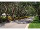 Landscaped entrance lined with mature trees and colorful flowers at 523 Fallbrook Dr, Venice, FL 34292