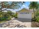 House exterior featuring a yellow facade, white garage, and landscaped yard at 523 Fallbrook Dr, Venice, FL 34292