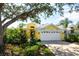 Bright yellow house with a white garage door, nicely landscaped at 523 Fallbrook Dr, Venice, FL 34292