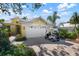 Charming yellow house with a white garage door and a golf cart at 523 Fallbrook Dr, Venice, FL 34292