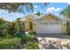 Bright yellow house with white garage and well-manicured landscaping at 523 Fallbrook Dr, Venice, FL 34292