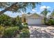 Landscaped yard with a yellow house and white garage at 523 Fallbrook Dr, Venice, FL 34292