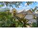 Attractive yellow house with lush landscaping and a white garage door at 523 Fallbrook Dr, Venice, FL 34292